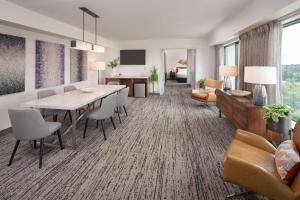 a dining room with a table and chairs and a living room at Hilton Fairfax, Va in Fairfax