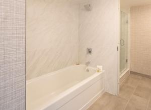 a white bath tub in a bathroom with a shower at Hilton Fairfax, Va in Fairfax