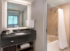 a bathroom with a sink and a bath tub at Hilton Fairfax, Va in Fairfax