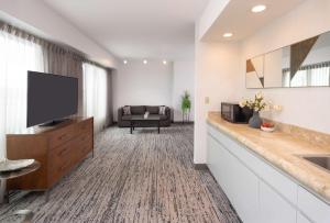 a living room with a television and a couch at Hilton Fairfax, Va in Fairfax