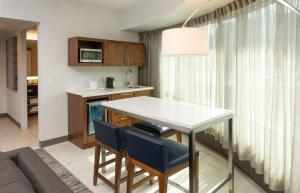 a kitchen and living room with a table and chairs at Hilton Fairfax, Va in Fairfax