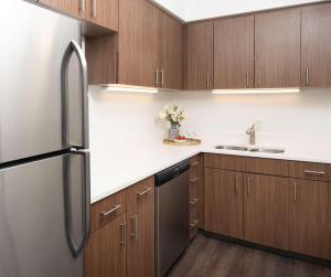 a kitchen with wooden cabinets and a stainless steel refrigerator at Hilton Fairfax, Va in Fairfax