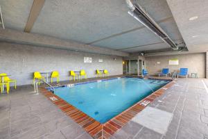 una grande piscina con sedie e sedie in una camera d'albergo di Home2 Suites By Hilton Bryant, Ar a Bryant