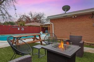 a backyard with a table and chairs and a fire pit at 5BR 2B with Pool Fire Pit & Jacuzzi - 11 Guests in Irving