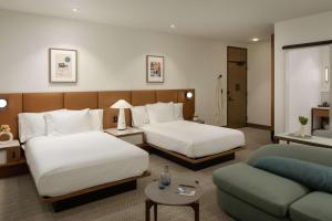 Habitación de hotel con 2 camas y sofá en Hotel Marcel New Haven, Tapestry Collection By Hilton, en New Haven