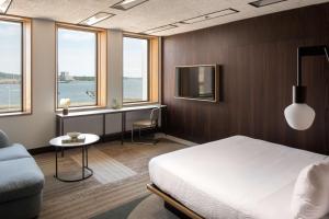 a bedroom with a bed and a desk and windows at Hotel Marcel New Haven, Tapestry Collection By Hilton in New Haven