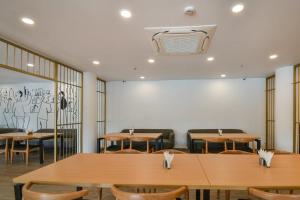 une salle à manger avec des tables et des chaises en bois dans l'établissement Super Townhouse 596 Hotel KG Estate, à Jaipur