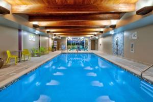 Home2 Suites By Hilton Grand Rapids South في Byron Center: حمام سباحة بمياه زرقاء في غرفة في الفندق