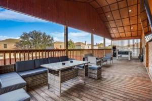 un patio con una mesa y bancos en una terraza en Villa in Grand Prairie with pool sauna hot tub and more, en Grand Prairie