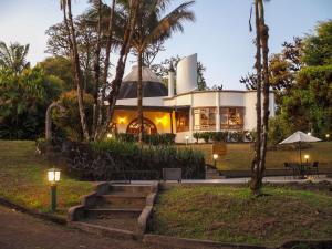 une maison avec des palmiers devant elle dans l'établissement Royal Palm Galapagos, Curio Collection Hotel by Hilton, à Bellavista