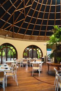 ein Esszimmer mit Tischen, Stühlen und einer Decke in der Unterkunft Royal Palm Galapagos, Curio Collection Hotel by Hilton in Bellavista