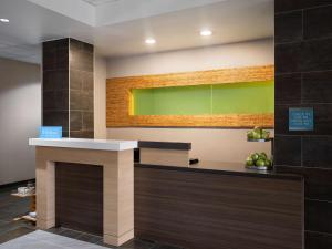 a bar in a lobby with a green wall at Home2 Suites by Hilton Indianapolis - Keystone Crossing in Indianapolis