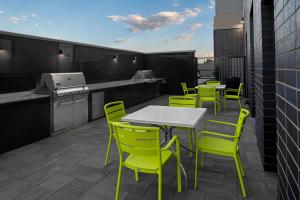 a patio with yellow chairs and tables and a kitchen at Home2 Suites By Hilton Hobbs in Hobbs