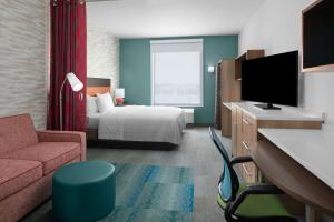 a hotel room with a bed and a tv at Home2 Suites By Hilton Hobbs in Hobbs