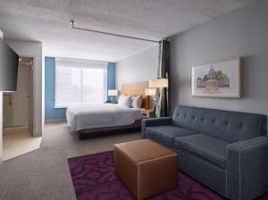 a hotel room with a couch and a bed at Home2 Suites by Hilton Indianapolis - Keystone Crossing in Indianapolis