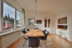 a dining room with a wooden table and chairs at Ferienhaus Aalweg in Niendorf