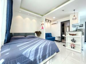 1 dormitorio con 1 cama azul y 1 silla azul en PTH Residence, en Phnom Penh