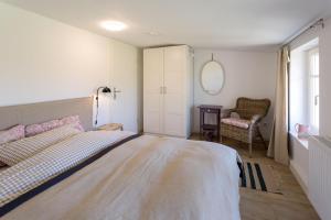 - une chambre avec un grand lit et une chaise dans l'établissement Herthaquelle Wohnung 5 "Das Nest", à Garz