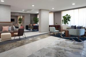 a lobby of a hotel with chairs and tables at The Chifley Houston, Tapestry Collection by Hilton in Houston