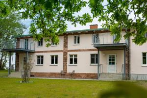 una vista exterior de una casa con patio en Herthaquelle Wohnung 3 "Die Rose", en Garz