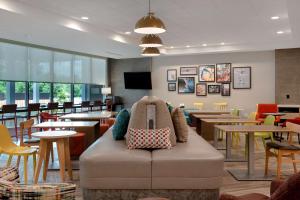 a waiting room with a couch with pillows on it at Home2 Suites By Hilton Fayetteville North in Fayetteville