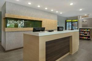 a lobby of a store with a laptop on a counter at Home2 Suites By Hilton Grand Rapids Airport in Kentwood