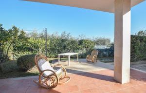 dwa krzesła i stół na patio w obiekcie Lovely Home In Marina Di Modica With Jacuzzi w mieście Marina di Modica