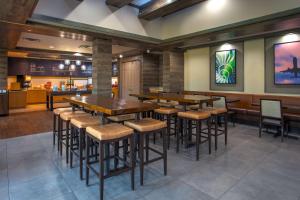 a restaurant with wooden tables and stools at Hampton Inn & Suites By Hilton- Newark Airport Elizabeth in Newark