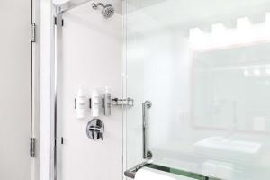 a white bathroom with a shower and a sink at Hampton Inn & Suites By Hilton- Newark Airport Elizabeth in Newark