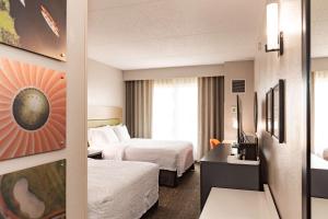 a hotel room with two beds and a desk at Hampton Inn & Suites By Hilton- Newark Airport Elizabeth in Newark