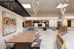 Doubletree By Hilton Fort Worth South في فورت وورث: قاعة اجتماعات مع طاولة وكراسي خشبية كبيرة