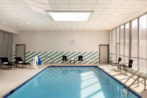 a swimming pool with chairs and tables in a building at Doubletree By Hilton Fort Worth South in Fort Worth