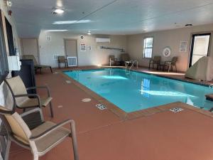 a large swimming pool in a hotel room with two chairs at Best Western Halito Inn in Calera