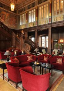 艾珍的住宿－明希豪森城堡酒店，大楼内带红色桌椅的大堂