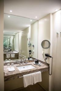 a bathroom with a sink and a large mirror at Schlosshotel Münchhausen in Aerzen