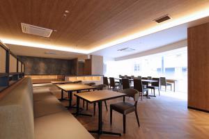 Best Western Plus Nagoya Sakae في ناغويا: مطعم بطاولات وكراسي ونافذة كبيرة