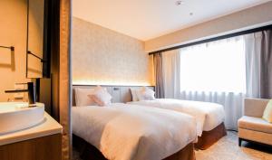 Best Western Plus Nagoya Sakae في ناغويا: غرفة فندقية بسريرين ومغسلة