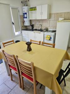 eine Küche mit einem Tisch mit Stühlen und einem Kühlschrank in der Unterkunft La Juanita in Junín de los Andes