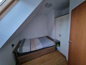 Dormitorio pequeño con cama en el ático en Macesen apartment Rogla, en Zreče