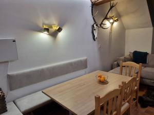 a dining room table with a bowl of oranges on it at Macesen apartment Rogla in Zreče