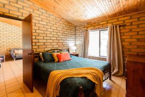 a bedroom with a bed and a brick wall at Turner Brook in Augusta