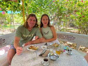 a man and woman sitting at a table with food at Đức Lưu Quang Hotel Bình Thuận in Tuy Phong