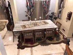 a dining room table with chairs and a white marble table at Luxury Villa in Rehab City in Cairo