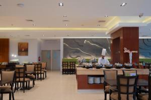 a restaurant with a chef in the middle of a room at The Capital Hotel Surabaya in Surabaya