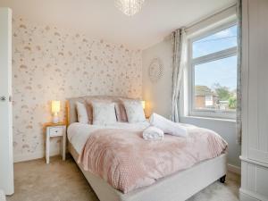 a bedroom with a bed and a window at Vine Cottage 