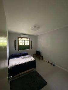 a bedroom with a large bed and a window at Casa Zohra in Itaparica