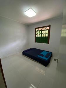 a room with a bed in a room with a window at Casa Zohra in Itaparica