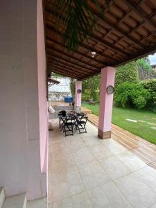 a patio with a table and chairs and a clock at Casa Zohra in Itaparica