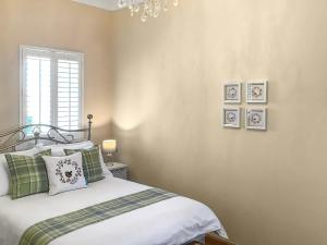 a bedroom with a bed with green and white pillows at Hilton Farm Steadings in Limekilns