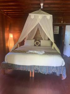 a large bed with a canopy in a room at Bulian Homestay in Kubutambahan